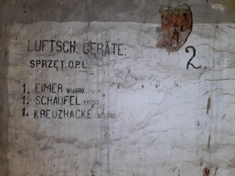Stanowisko obrony przeciwlotniczej na strychu jednego z budynków w Łazienkach Królewskich, uzupełnione w czasie okupacji o niemieckie napisy (widok  ściany z polskimi i niemieckimi napisami wojskowymi) Fot. Mariusz Kolmasiak/MŁK
